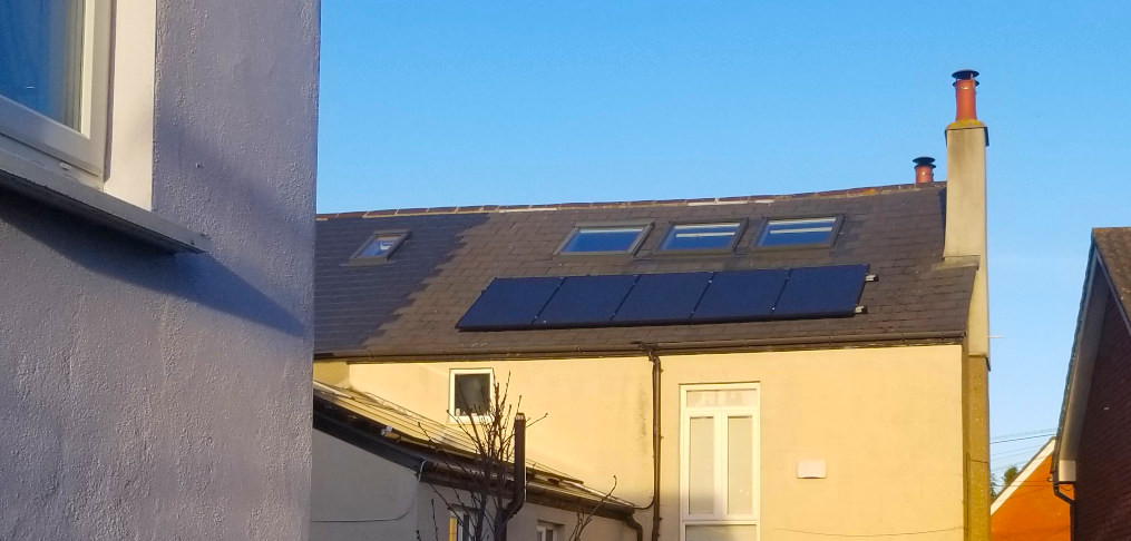 West-facing solar panels on the roof of a house in Ireland catch the evening sun