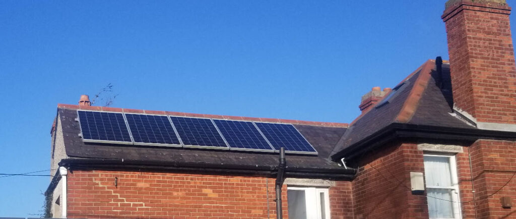 5 solar panels in a row on the roof of a brick house